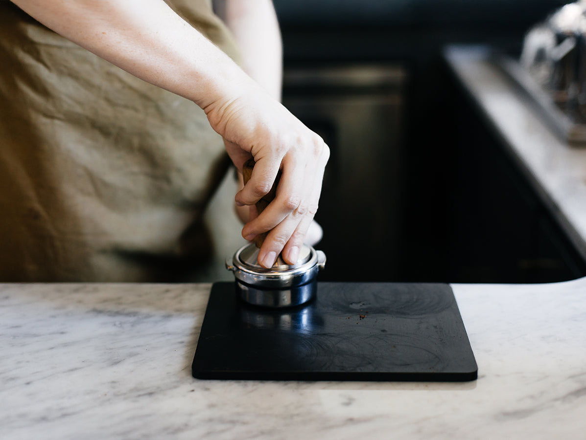 barista making tamping blonde espresso